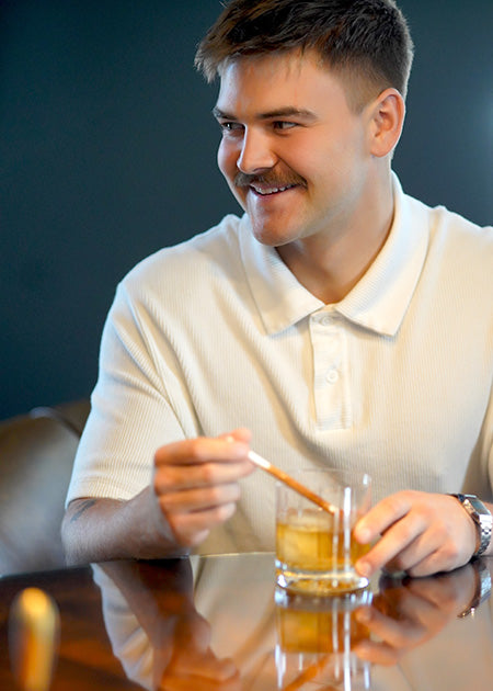 Man Stirring Cocktail with Seasoned Straw